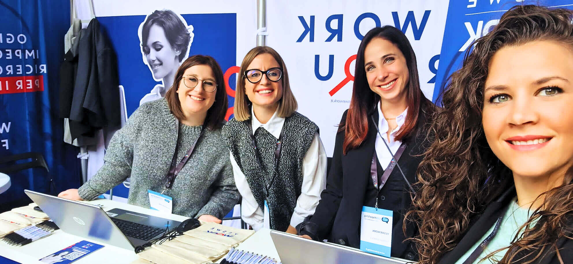 Le recruiter di YesWeWork sorridono dall'interno del loro stand al Job Meeting 2023 all'università la Sapienza di Roma