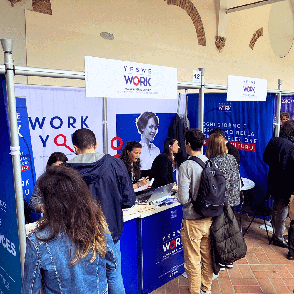 Giovani candidati partecipanti al Job Meeting 2023 di Roma sono allo stand di YesWeWork per parlare con le recruiter