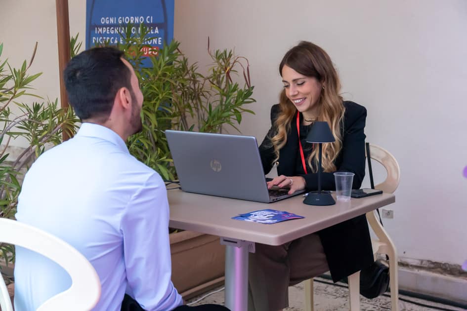 La recruiter di YesWeWork Sonia sorride mentre tiene un colloquio di lavoro ad un partecipante dell'ApeRecruiting Trani