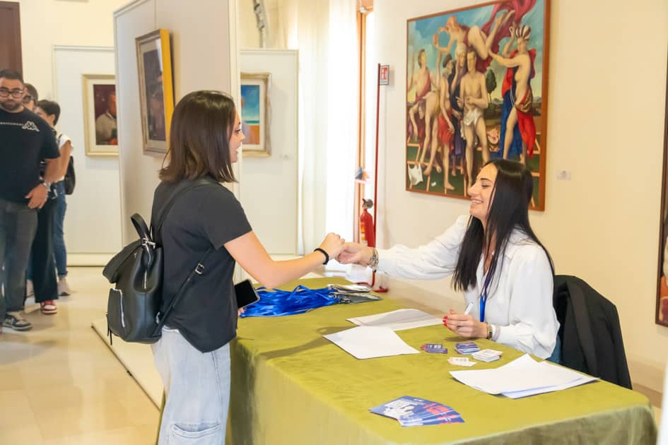 L'addetta alla reception dell'ApeRecruiting Job Day consegna i ticket per le consumazioni ad una delle partecipanti
