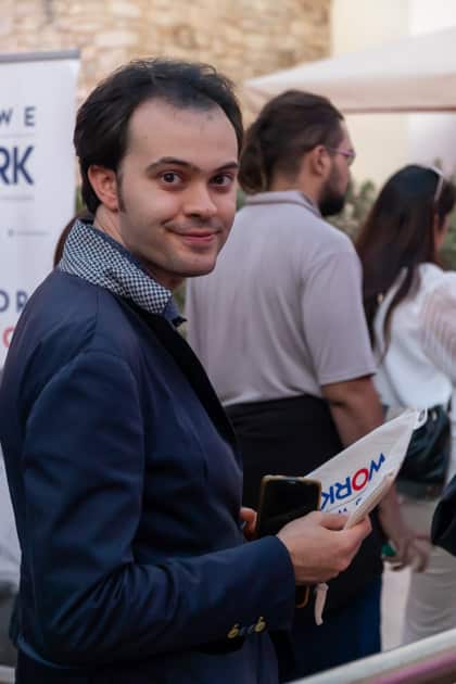 Uno dei partecipanti all'ApeRecruiting attende il suo turno per un colloquio. Ha in mano la pochette omaggio di YesWeWork