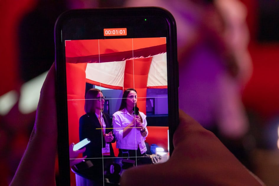 Le recruiter Erika e Giorgia inquadrate da un telefonino mentre tengono un'intervista con Radio Selene all'ApeRecruiting