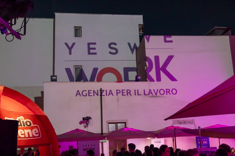 Il Logo di YesWeWork proiettato su una delle pareti perimetrali del Palazzo Beltrani, sede dell'ApeRecruiting Trani 2024