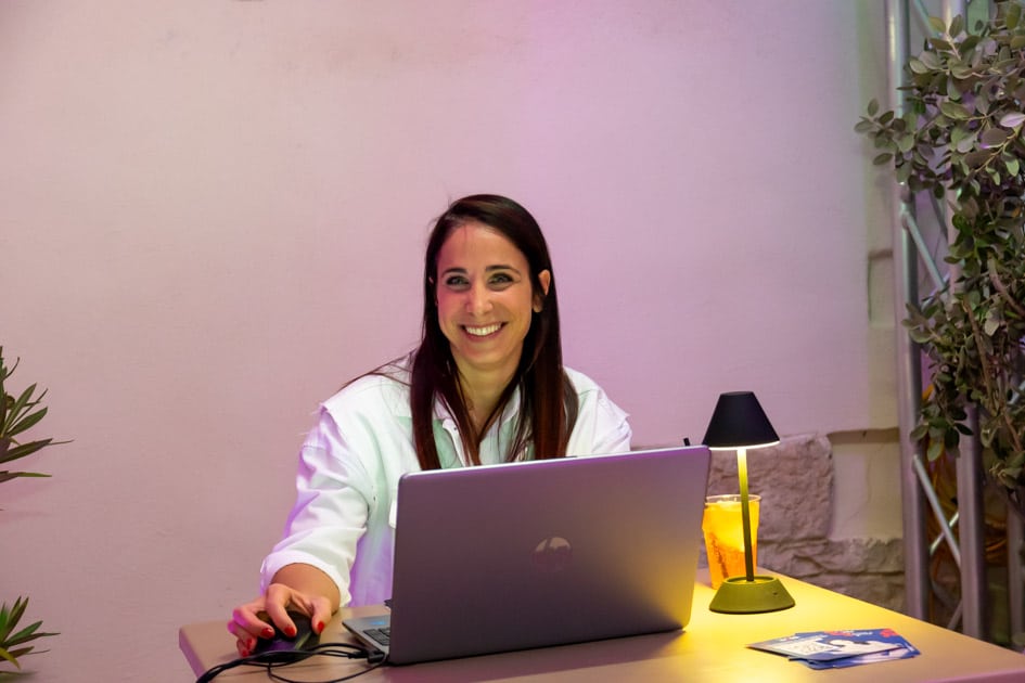 La recruiter di YesWeWork Giorgia, sorride dalla sua postazione di colloquio all'ApeRecruiting durante un momento di pausa