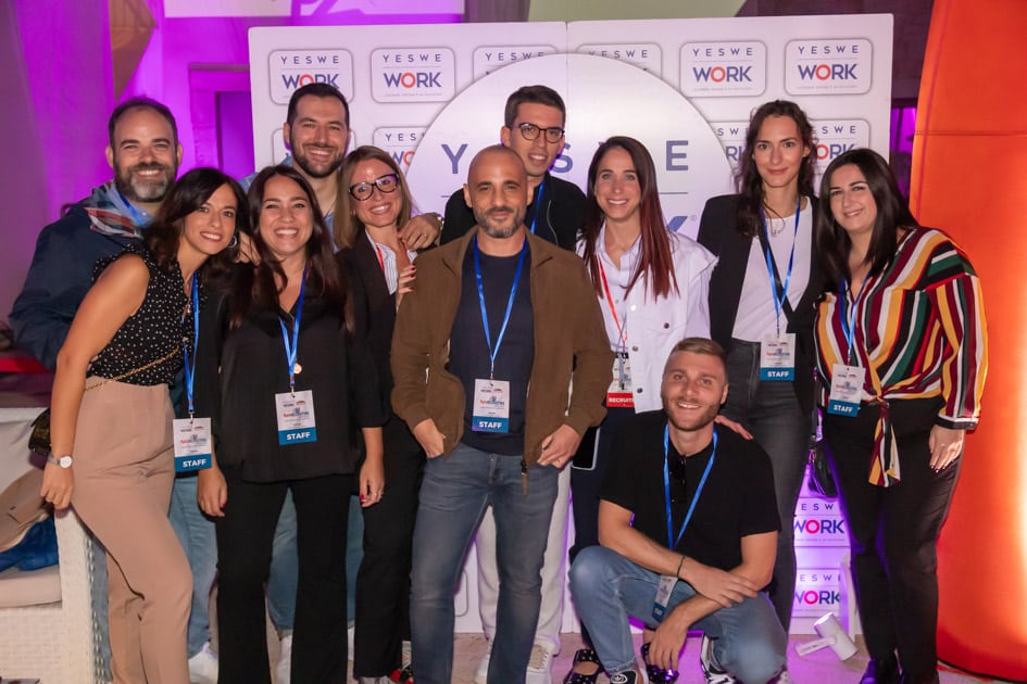 Parte del team YesWeWork posa per una foto di gruppo di fronte ad un pannello brandizzato durante l'ApeRecruiting Trani