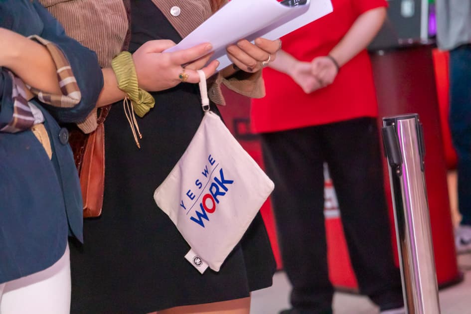 Una pochette brandizzata, Gadget omaggio di YesWeWork, tenuta da una ragazza durante l'evento ApeRecruiting