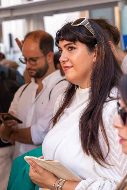 Una ragazza in fila per un colloquio all'ApeRecruiting Job Day Trani. Ha l'aria serena e in mano la pochette di YesWeWork