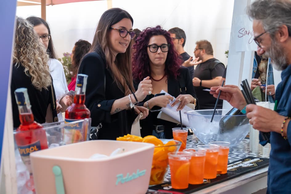 Due ragazze attendono i propri drink al Bar dell'ApeRecruiting Job Day Trani mentre il barista li sta preparando
