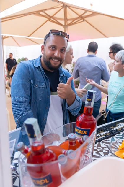 Un partecipante all'ApeRecruiting di Trani alza il pollice in segno di soddisfazione mentre attende il suo drink al bar