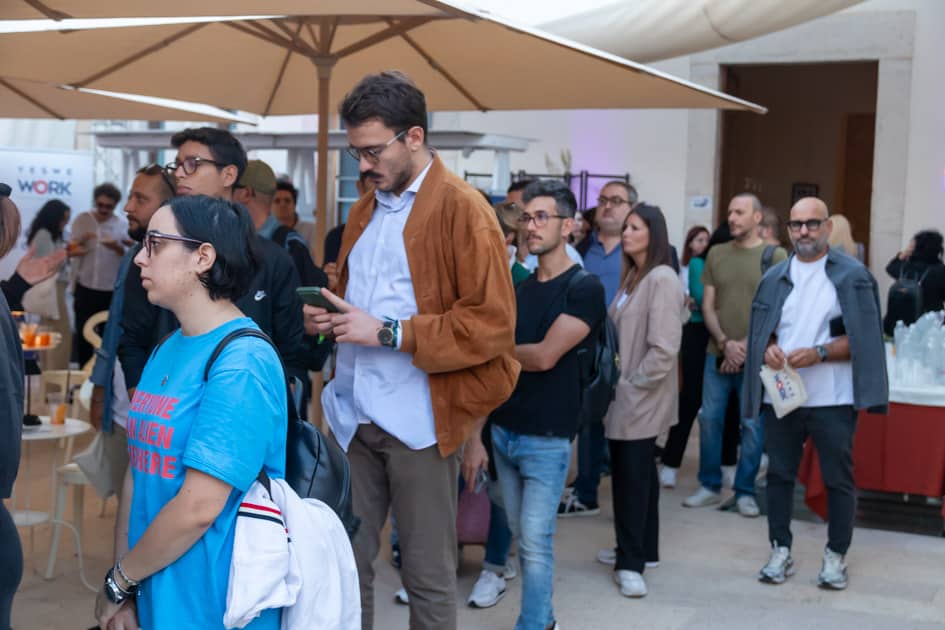 Partecipanti all'ApeRecruiting Trani: alcuni si rilassano nell'area aperitivo e altri fanno la fila per il colloquio