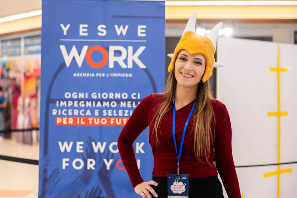 Domadraghi Cosplay, ospite dell'evento YesWeNERD, fa una foto di fianco ad un roll-up brandizzato YesWeWork