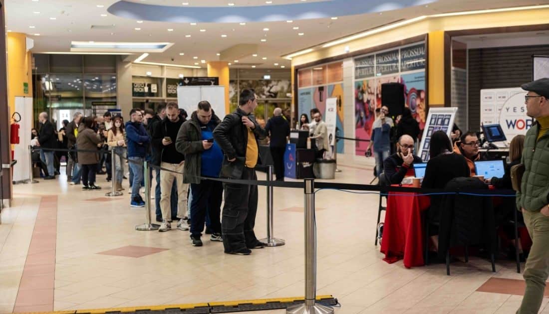 Tantissimi candidati stanno educatamente in fila in attesa del loro turno per accedere all'area colloqui dell'ApeRecruiting