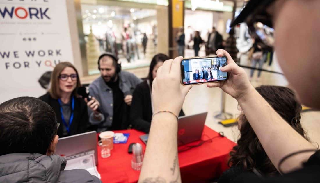 Qualcuno sta riprendendo con il proprio smartphone Luca Catalano mentre intervista le recruiter all'ApeRecruiting