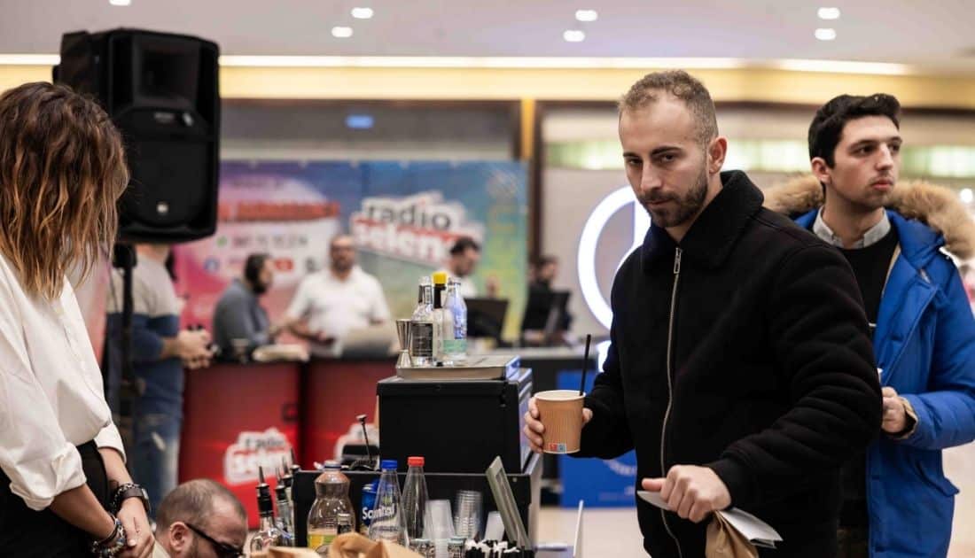 Un ragazzo ha appena ritirato il suo drink dall'angolo Bar dell'ApeRecruiting Job Day Casamassima