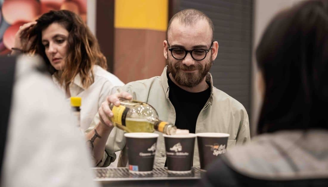 Il Barista dell'ApeRecruiting Job Day Casamassima sorride ad alcuni dei ragazzi presenti mentre gli prepara uno Spritz
