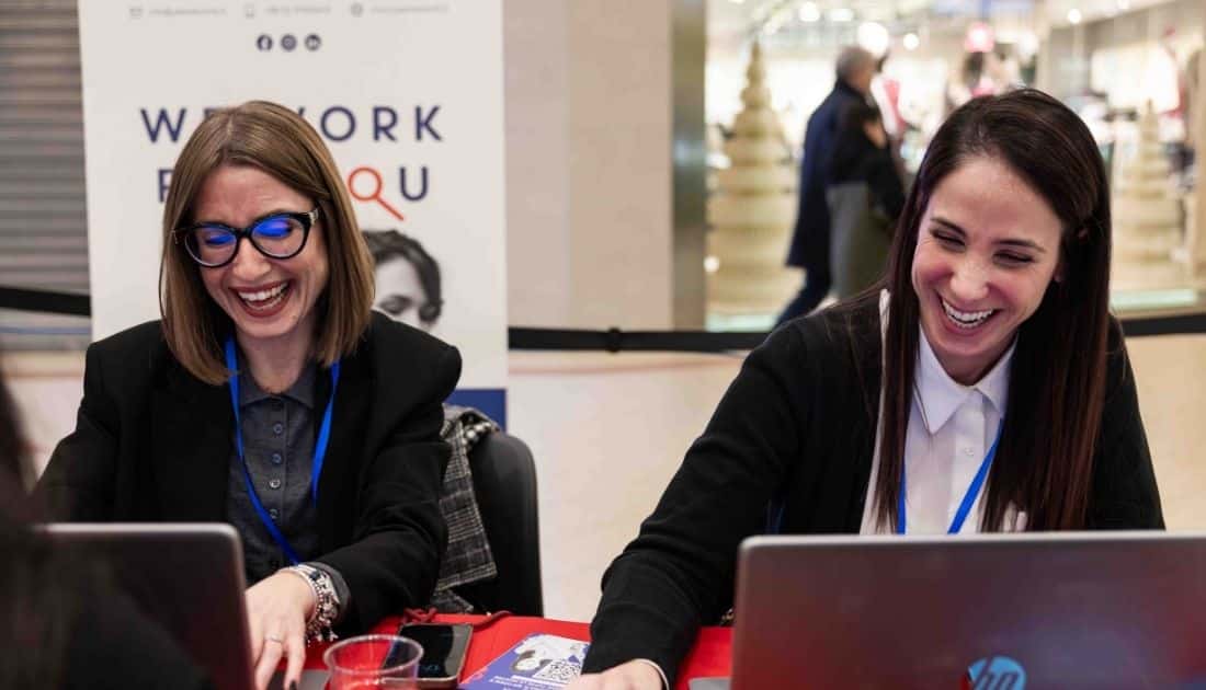 Nell'area dei Colloqui di Lavoro dell'ApeRecruiting, due Recruiter ridono allegre mentre sono sedute davanti ai loro computer