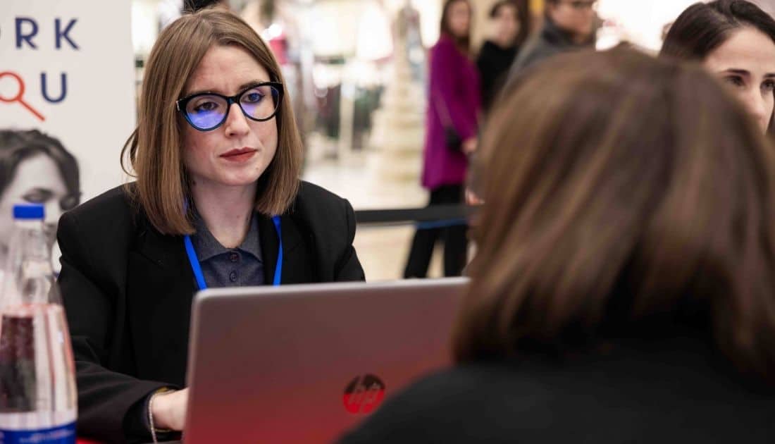 La recruiter Erika ascolta attentamente una candidata durante un colloquio di lavoro all'ApeRecruiting Job Day di YesWeWork