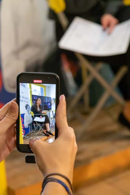 Inquadratura di uno smartphone tenuto in mano da una persona che inquadra la recruiter Giorgia Vernola durante il suo speech
