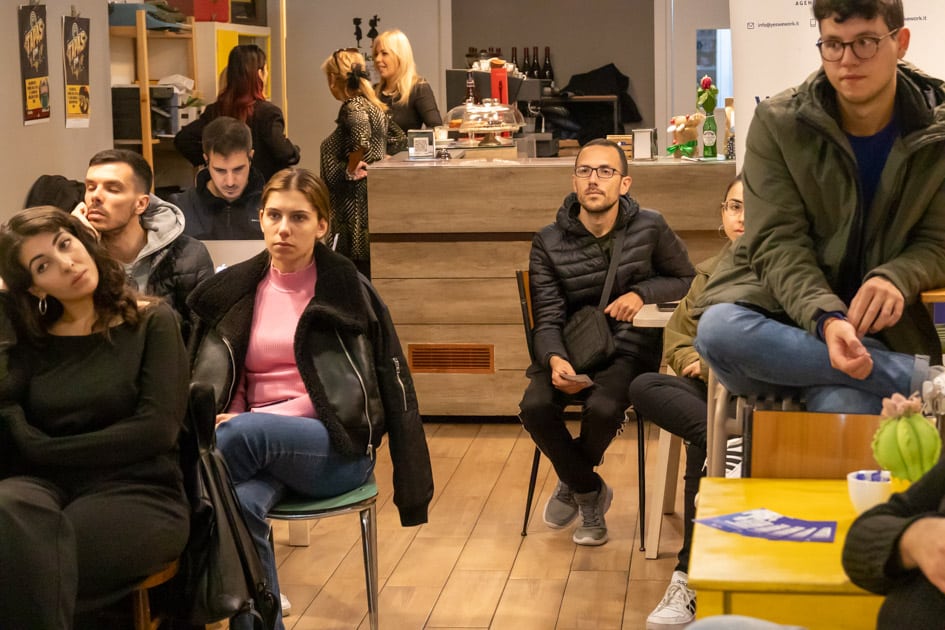 Un gruppo di persone nel Caffè Portineria durante l'evento 'Caffè con YesWeWork': si percepisce un'atmosfera intima e piacevole
