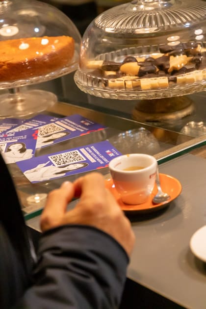 Taglio su una tazzina di caffè e un po' di volantini di YesWeWork al banco del caffè portineria