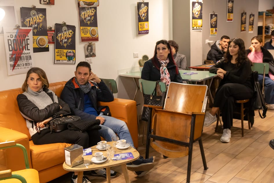 Alcune persone all'interno del Caffè Portineria di Bari sono intente ad ascoltare i consigli della recruiter di YesWeWork
