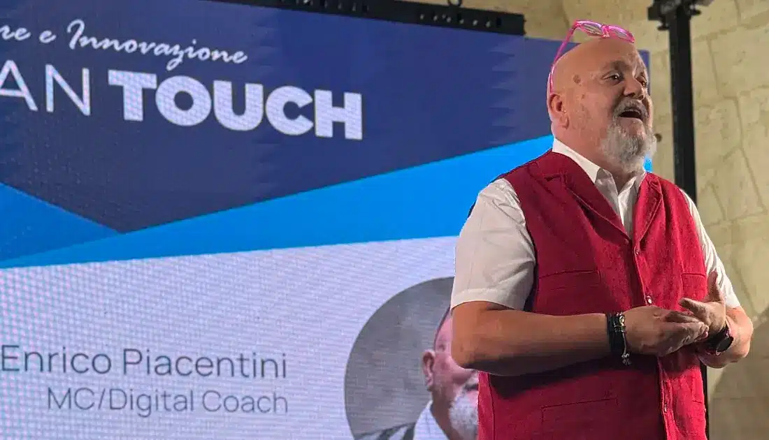 Enrico Piacentini, sul palco, rivolto al pubblico, dà il via all'evento di YesWeWork 'Human Touch'