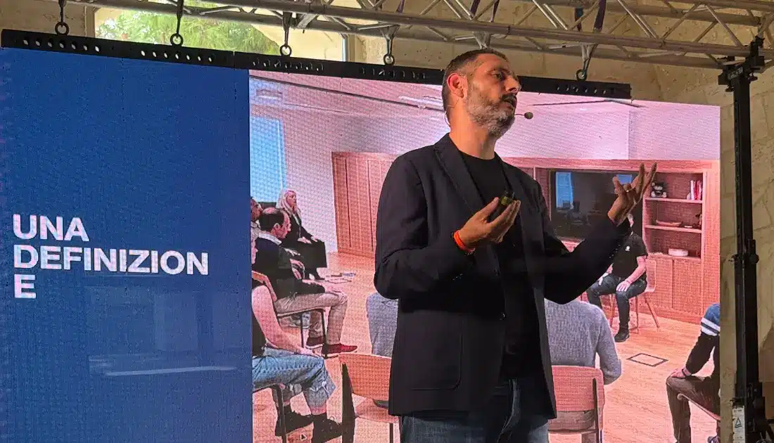 Fabio Cutrera parla di meditazione alla platea dell'evento 'Human Touch' supportato da slide su maxischermo