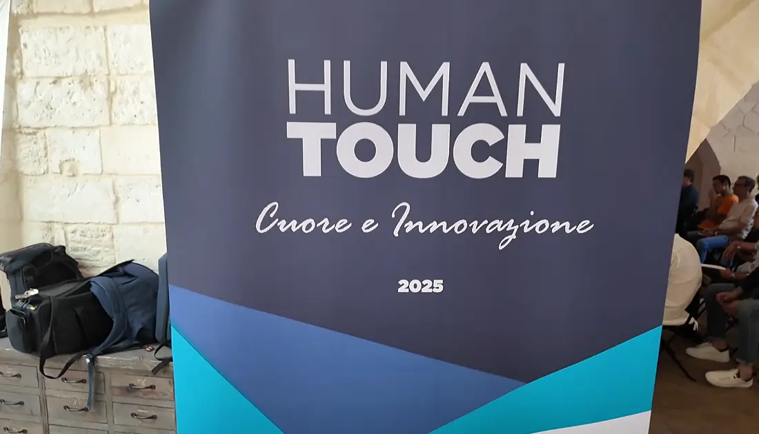Una foto della parte superiore di un Roll-Up di 'Human Touch' che riporta il logo dell'evento