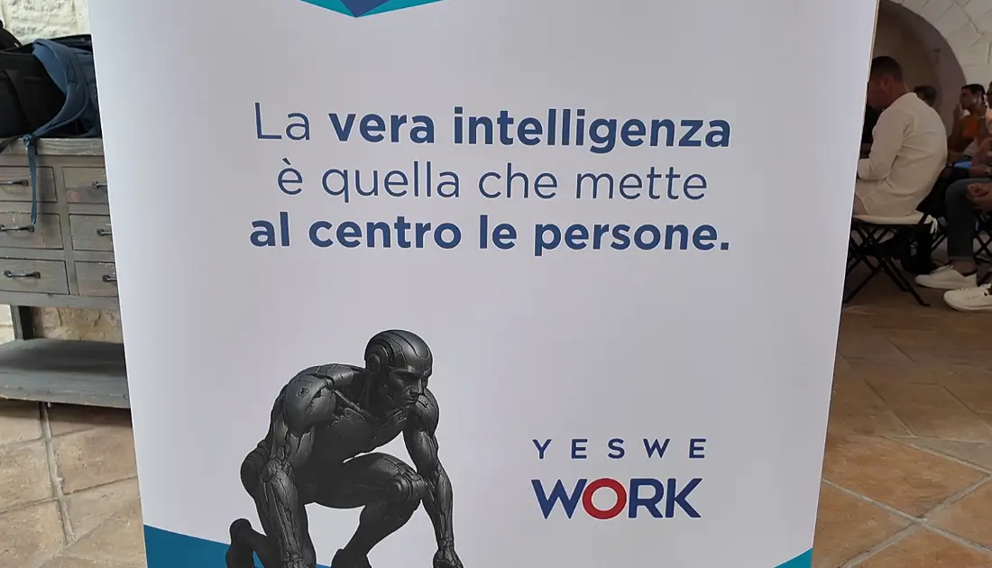 Un Roll-Up dell'evento 'Human Touch' riporta lo slogan 'la vera intelligenza è quella che mette al centro le persone'