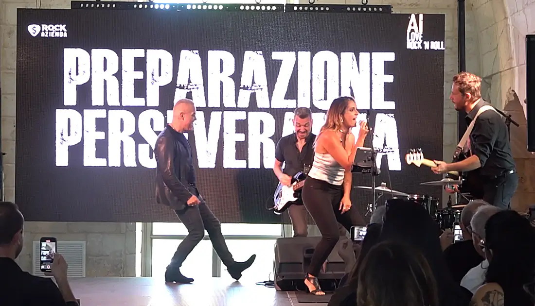Max Panìco e band si esibiscono a 'Human Touch'. Sul maxischermo compare la scritta 'preparazione, perseveranza'