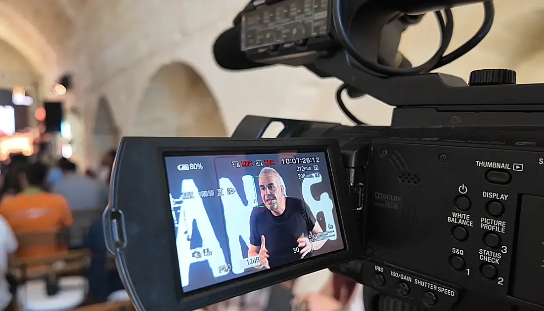 Una videocamera in primo piano sta riprendendo l'esibizione di Max Panìco dalla platea dell'evento 'Human Touch'