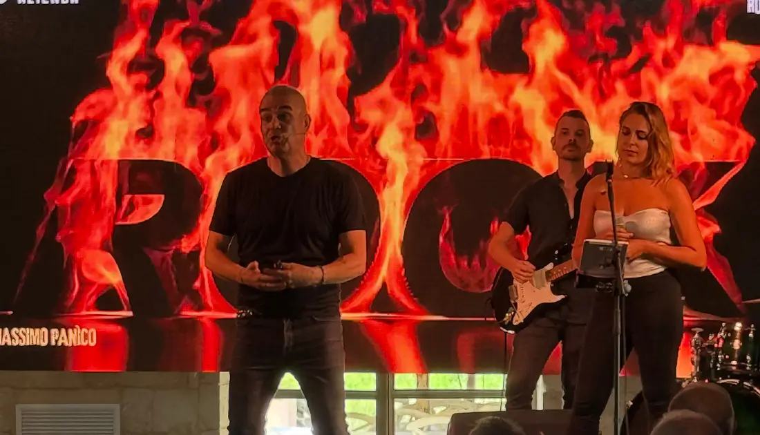 Max Panìco e band sul palco di 'Human Touch'. Sul maxischermo compare la scritta 'rock' circondata dalle fiamme
