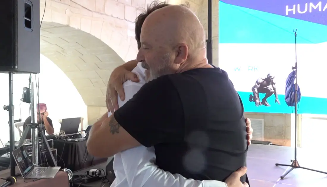 Stefano Chiodaroli abbraccia un ragazzo del pubblico a bordo palco, coinvolgendolo in un suo sketch comico